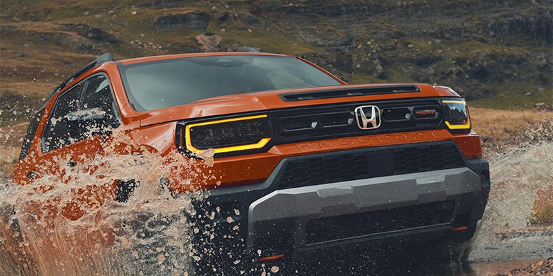 Honda Passport TrailSport splashing through river crossing in the mountains